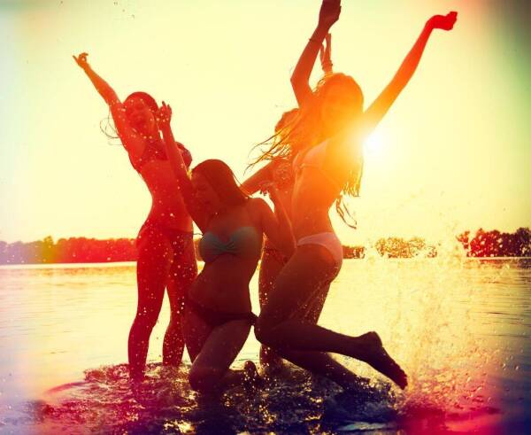 Beach Party. Teenage girls having fun in water. Group of happy y